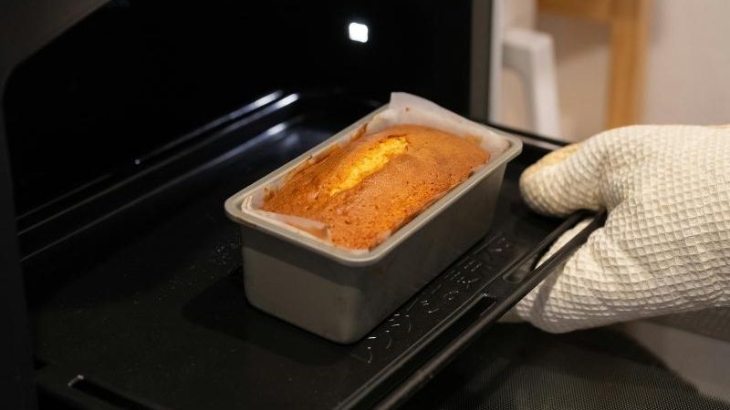 tangan sedang memanggang kue dalam oven