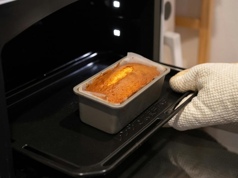 tangan sedang memanggang kue dalam oven